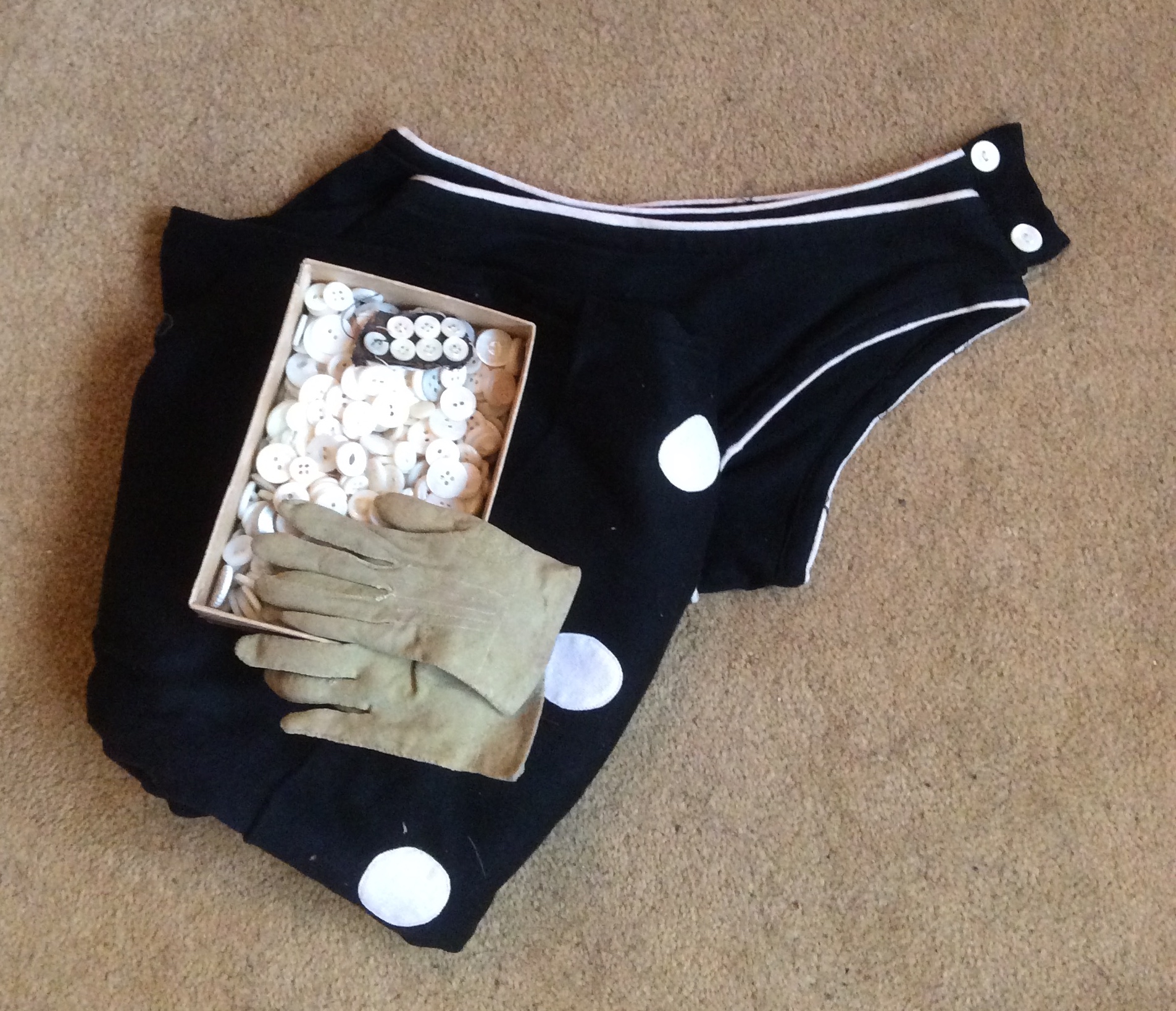 A 1920's bathing costume, child's kid gloves and a box pearl buttons