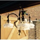 Hanging brass light fitting with three cut glass shades.