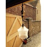 Small hanging brass light with frosted glass shade.