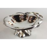 A plated circular cake basket with swivel handle on stemmed base
