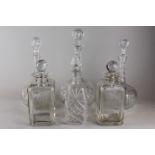 A pair of clear glass wine decanters with facet cut bodies (odd stoppers), a pair of clear glass