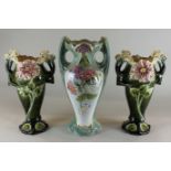 A pair of continental Art Nouveau green Majolica vases with floral decoration and a French two-