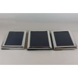 A pair of plain rectangular silver photograph frames (different makers), 22cm by 17cm, and another