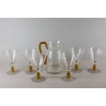 A glass lemonade/water set of jug and six glasses, with orange stems and frosted bases