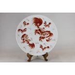 A large oriental circular dish, hand painted with snarling dogs, in brown on stand, 40cm diameter