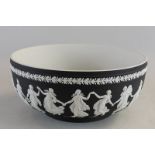 A large Wedgwood Jasperware bowl depicting women in classical dress dancing on a black ground