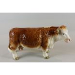 A Hereford cow, glazed in brown and white, standing, 14cm high