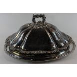 A heavy plated oval dish cover with lobed body and leaf handle, 40cm by 28cm, with an associated