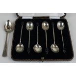 A set of six bean handled silver coffee spoons in case and a silver teaspoon