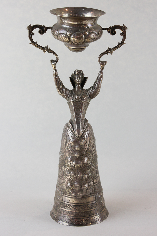 A 19th century Dutch silver wager cup, import marks for London 1897, modelled as a lady in crinoline