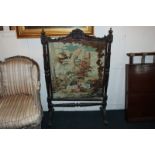 A Victorian carved walnut framed fire screen with petit-point panel of a parrot and a basket of