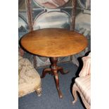 A George III oak tea table with circular tilting top on turned column and tripod base, 78cm