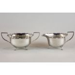 A silver cream jug and sugar bowl, Birmingham 1926, with oval bodies and waved rims on pad feet, 9.