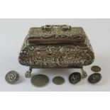 A Dutch silver casket embossed with allegorical scenes on floral legs containing three buttons and