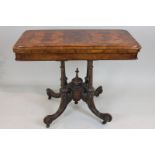 A Victorian figured walnut card table with rectangular folding swivel top, on four reeded columns