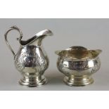 A continental silver cream jug and sugar bowl (800 mark) with floral embossed bodies and vacant