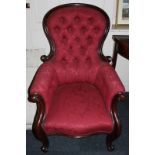 A Victorian mahogany framed armchair with show wood frames and button back, with scroll arms and