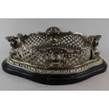 A continental silver coloured metal fruit bowl, the oval bowl with pierced sides and mermaids