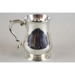 An early George III silver mug, maker I T London 1761, with scroll handle on circular base (