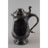 An 18th century Sheffield plate tankard with hinged lid, baluster body and scroll handle