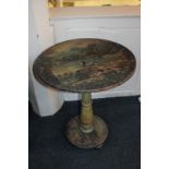 An unusual painted circular occasional table with distressed scene of figures at a waterfall beneath