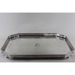 A heavy plated rectangular tea tray with pierced gallery and initialled I, on four bun feet, 52cm by