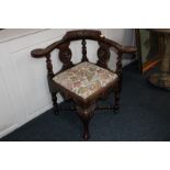 A Victorian carved oak corner chair with mask splat back and padded seat, with cabriole and claw and