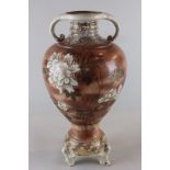 A Japanese satsuma two-handled vase, baluster shape, raised on three scroll feet, decorated with