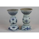 A pair of Chinese 20th century blue and white candle holders with circular bowl tops and bases and