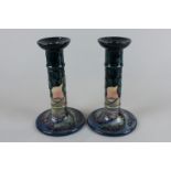 A pair of modern Moorcroft candlesticks decorated with trees in a landscape, 20cm high