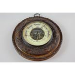 A Victorian aneroid barometer with scale 27 to 31 inches and marker and pointer, in carved