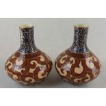 A pair of 20th century pottery vases with brown and gilt scroll decorated squat circular bodies