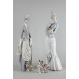 Two Lladro figures of ladies with dogs and another individual dog ornament, tallest 37.5cm high