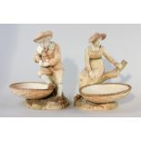 A pair of Hadley Royal Worcester porcelain ornaments of young girl and boy resting on branches