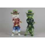 Two Continental Majolica cat character figures, one in green glaze, both standing wearing hats and