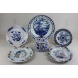 A Delftware circular pot and cover with mask mounts, a pair of plates (repaired), a bowl, 28cm,