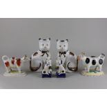 A pair of large Staffordshire cats, 20cm high, another smaller pair and two Staffordshire creamers