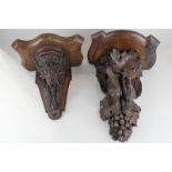 Two carved wood wall brackets decorated with rams head and dead game and fruit (NC)