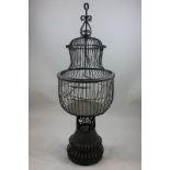 A wrought iron and wirework bird cage, 120cm high, (NC)