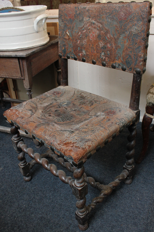 A Cromwellian style single chair with embossed leather back and seat (distressed), on spiral