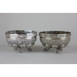 A pair of Indian silver bowls profusely chased on dolphin legs, 7oz
