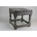 A 17th century oak stool, square top (now in two parts) on turned supports and stretchers (a/f),