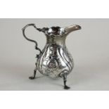 A George II silver cream jug, London 1755 (later embossed and maker's mark rubbed), with scroll