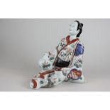 A Japanese porcelain figure of a seated geisha woman (some damage), 25cm high, (NC)