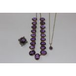 An amethyst and diamond brooch/pendant oval cut within a border of graduated bead set old cut