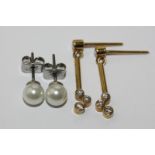 A pair of diamond drop earrings collet set with three stones beneath a baton and a single stone, a