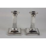 A pair of Victorian silver candlesticks, dwarf column form on loaded square bases, maker Thomas