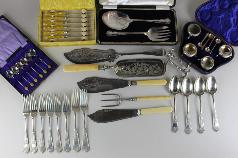 An assortment of silver plated flatware to include servers, crumb scoops, butter knives (some