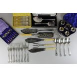 An assortment of silver plated flatware to include servers, crumb scoops, butter knives (some