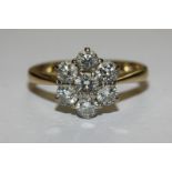 A diamond seven stone cluster ring the graduated round brilliant cuts claw set in 18ct gold